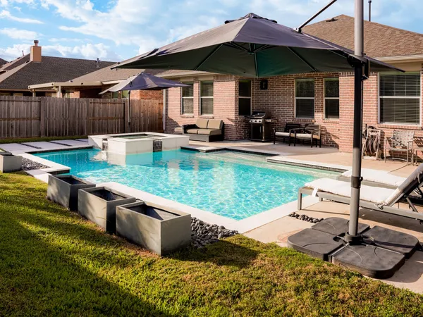 a view of a backyard with swimming pool