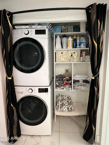 a view of walk in closet with clothes shoes washer and dryer