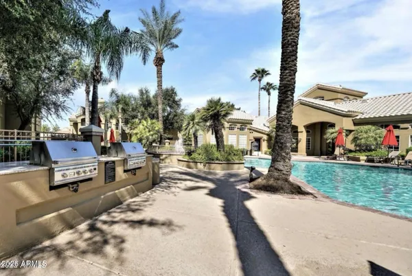 a row of palm trees sitting in front of a house with a big yard