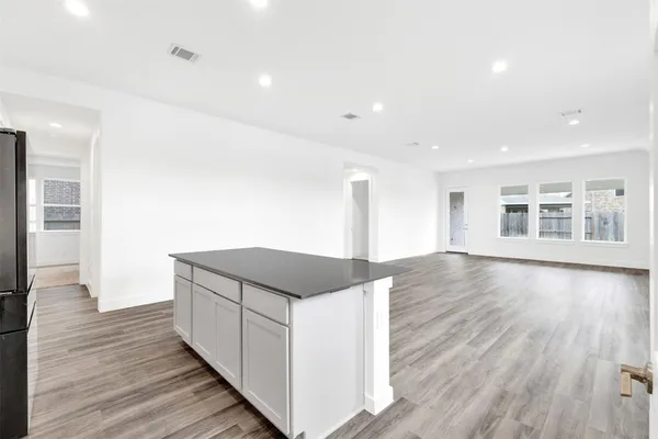a kitchen with stainless steel appliances granite countertop a sink and a wooden floors
