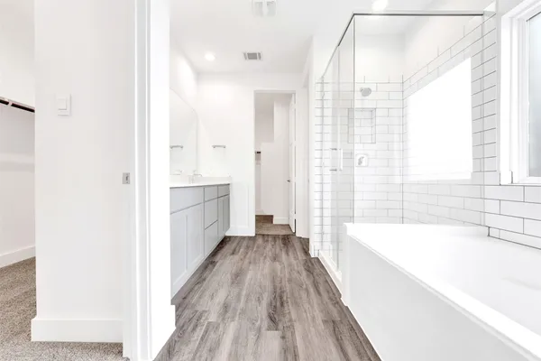 a spacious bathroom with a double vanity sink and mirror