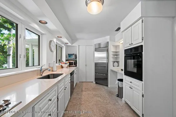 a kitchen with stainless steel appliances granite countertop a refrigerator and a sink