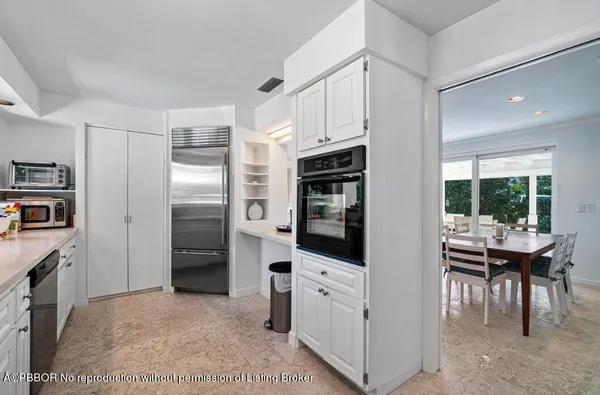 a kitchen with stainless steel appliances kitchen island granite countertop a refrigerator and a stove top oven