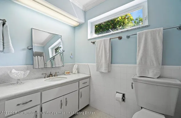 a bathroom with a sink and mirror with toilet