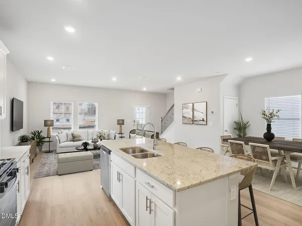 a kitchen with stainless steel appliances granite countertop a sink and a stove with wooden floor