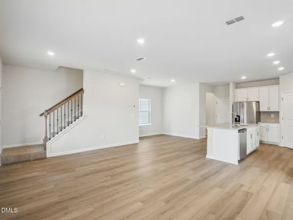a living room with furniture kitchen view and a flat screen tv