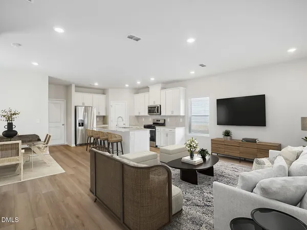 a view of kitchen with kitchen island wooden floor center island and stainless steel appliances