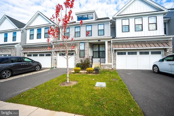 a view of a white house with large windows and a car park front of house