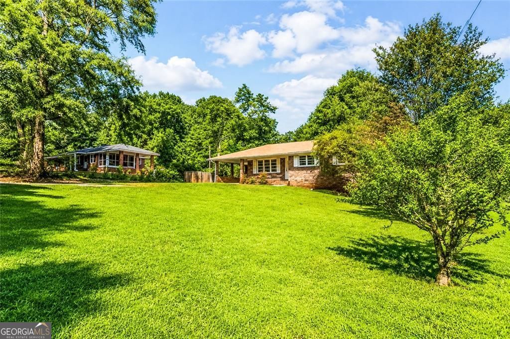 908 East Marable Street Monroe, GA 30656 - Photo 3 of 26 a white house with a big yard and large trees