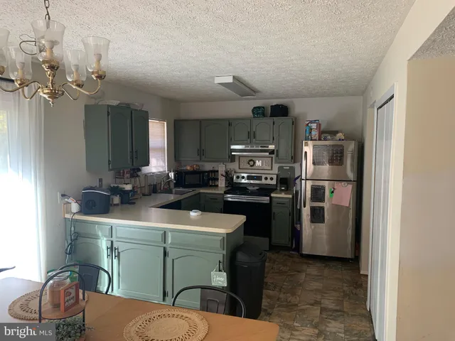 a kitchen with kitchen island a sink stove and refrigerator