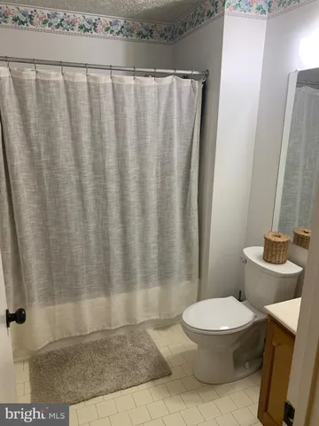 a white toilet sitting next to a shower curtain