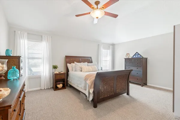 a bedroom with a bed chandelier and a window