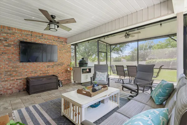 a living room with furniture a flat screen tv and a floor to ceiling window