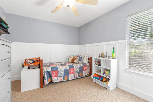 a bedroom with furniture and a chandelier fan