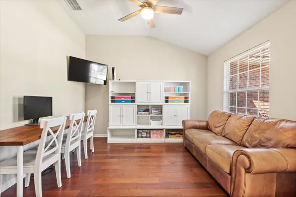 a room with a desk chair and painting on the wall