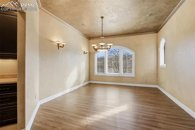 a view of an empty room with wooden floor fireplace and a window