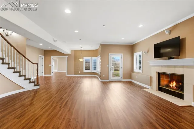 a view of a livingroom with fireplace wooden floor and windows