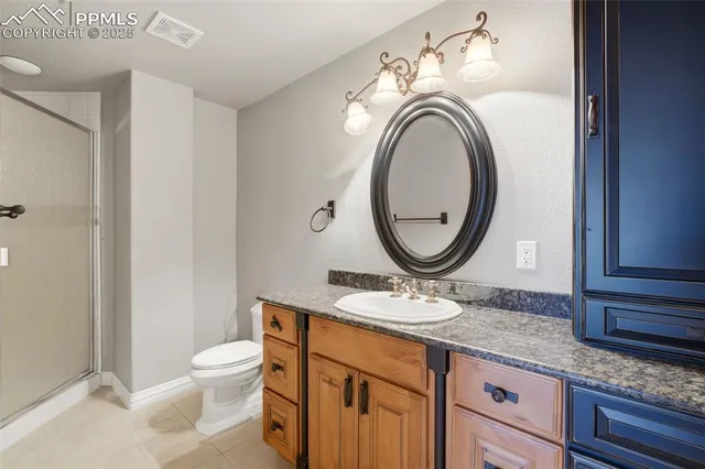 a bathroom with a granite countertop toilet sink and mirror