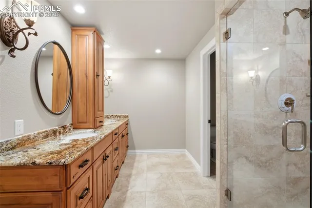 a bathroom with a granite countertop sink a mirror and a shower