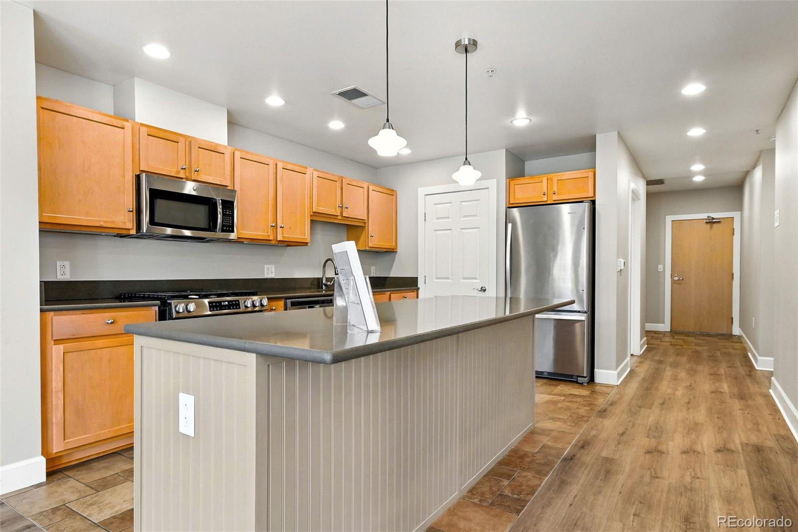 1631 Emerson Street, Unit 207 Denver, CO 80218 - Photo 11 of 30 a kitchen with stainless steel appliances granite countertop a refrigerator a stove and a sink