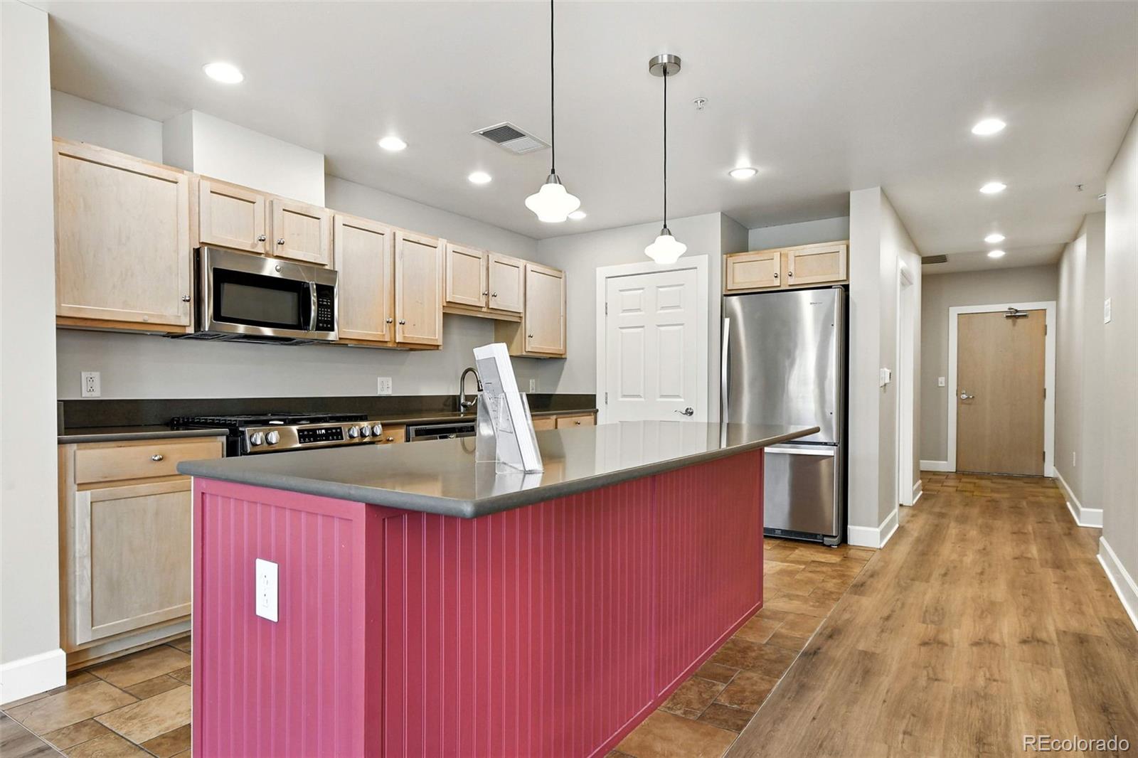 1631 Emerson Street, Unit 207 Denver, CO 80218 - Photo 12 of 31 a kitchen with stainless steel appliances granite countertop a refrigerator a stove a microwave and a wooden floors