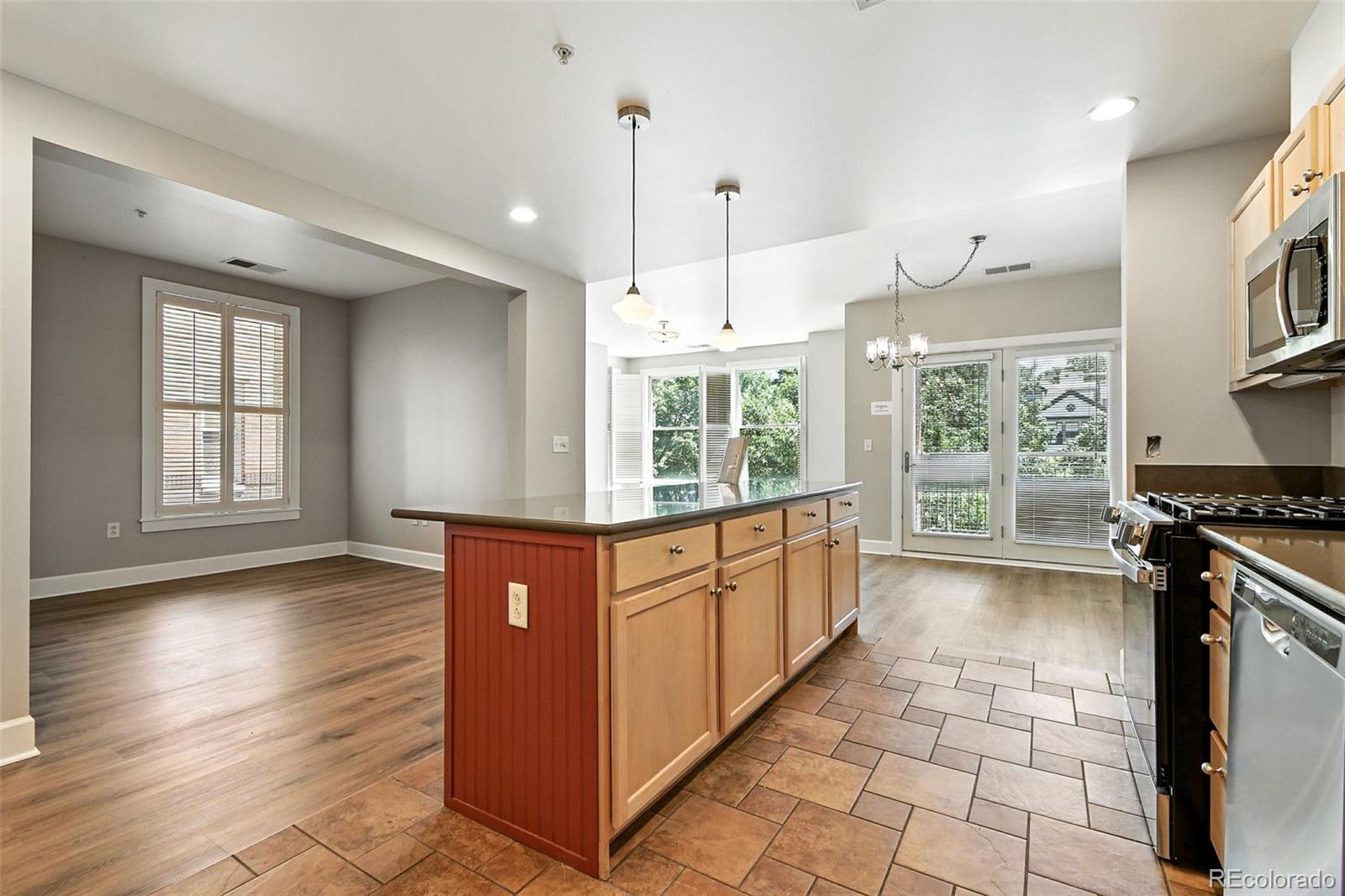 1631 Emerson Street, Unit 207 Denver, CO 80218 - Photo 10 of 31 a kitchen with stainless steel appliances granite countertop a stove a sink and a refrigerator with wooden floor