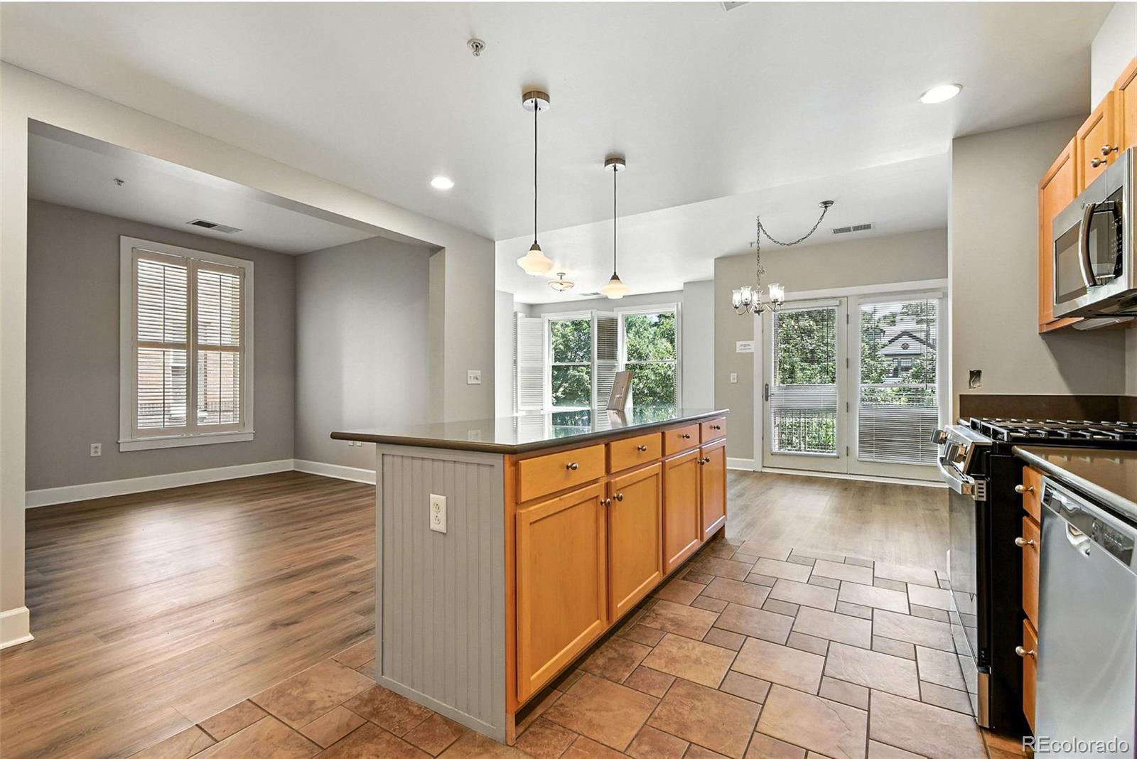 1631 Emerson Street, Unit 207 Denver, CO 80218 - Photo 10 of 30 a kitchen with stainless steel appliances granite countertop a stove a refrigerator a sink and a oven with wooden floor
