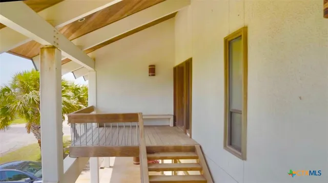 a view of an empty room with wooden floor and entryway