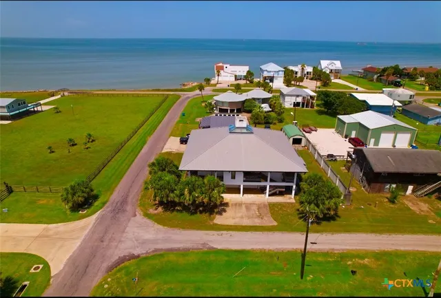 a aerial view of a house with swimming pool lawn chairs and yard