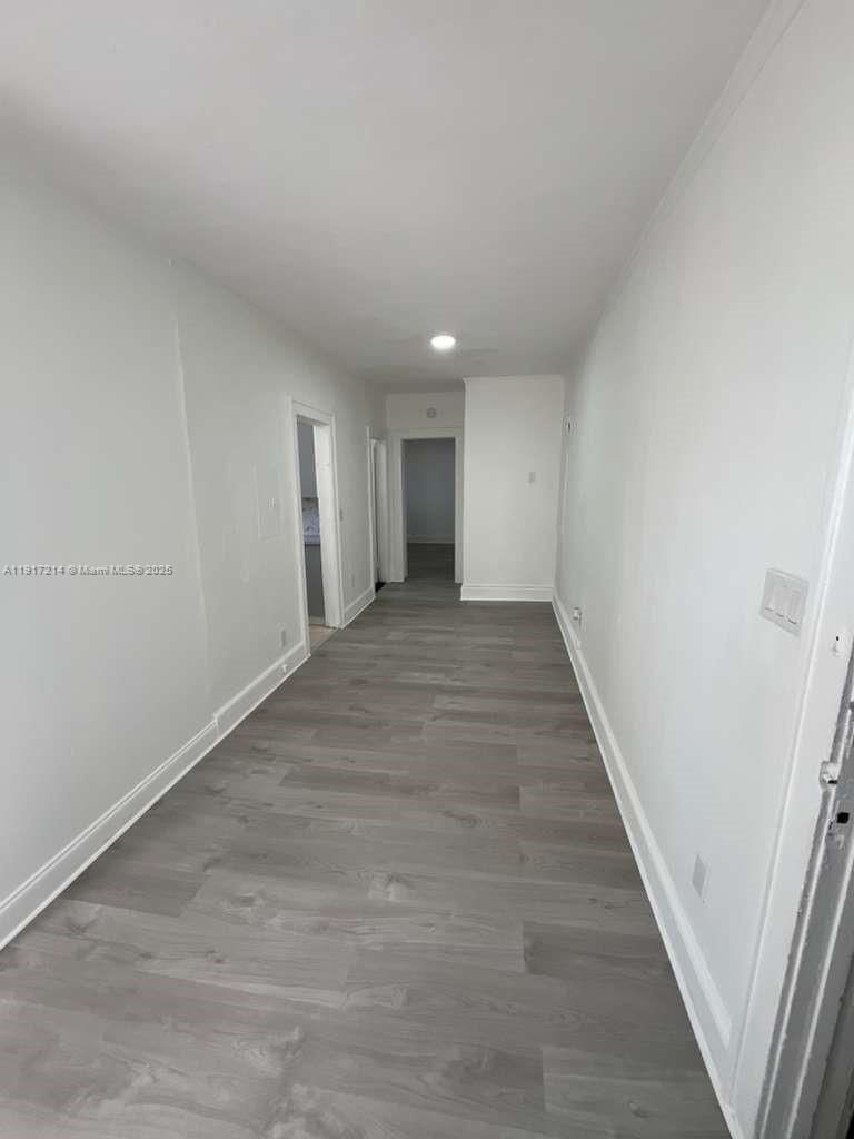 1560 Southwest 5th Street, Unit 11 Miami, FL 33135 - Photo 3 of 12 a view of an empty room with wooden floor