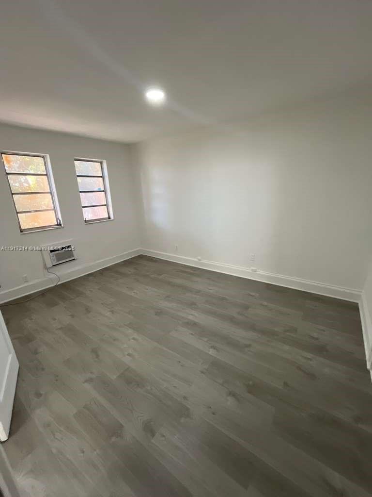 1560 Southwest 5th Street, Unit 11 Miami, FL 33135 - Photo 10 of 12 an empty room with wooden floor and windows