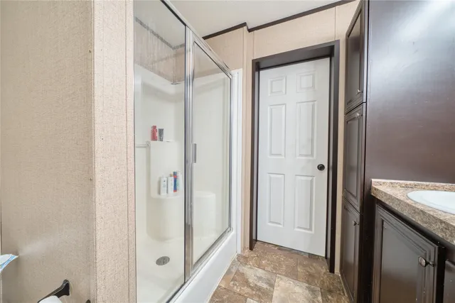a bathroom with a granite countertop shower and a sink