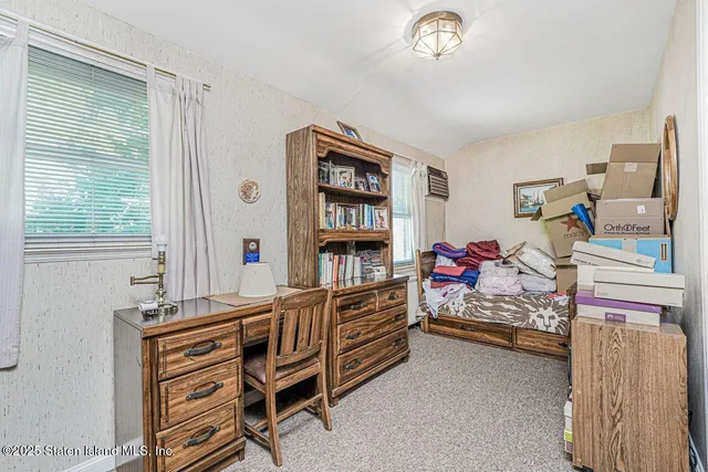 a view of an empty room with window and cabinet