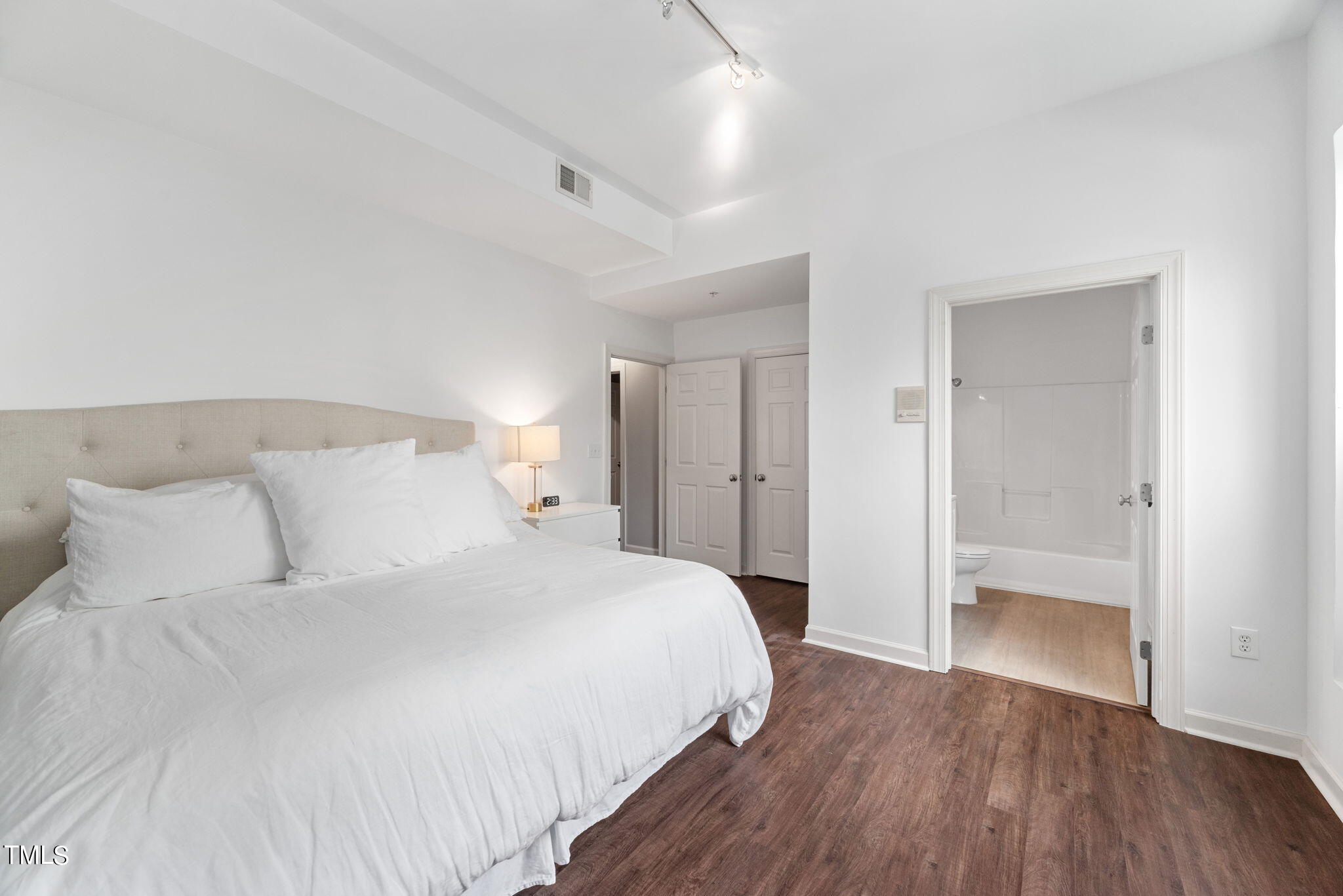 200 South Dawson Street, Unit 201 Raleigh, NC 27601 - Photo 26 of 39 a bedroom with a bed and a lamp