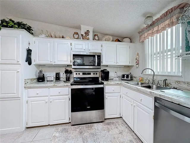 a kitchen with cabinets appliances a sink and a window