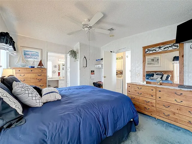 a spacious bedroom with a bed and dresser