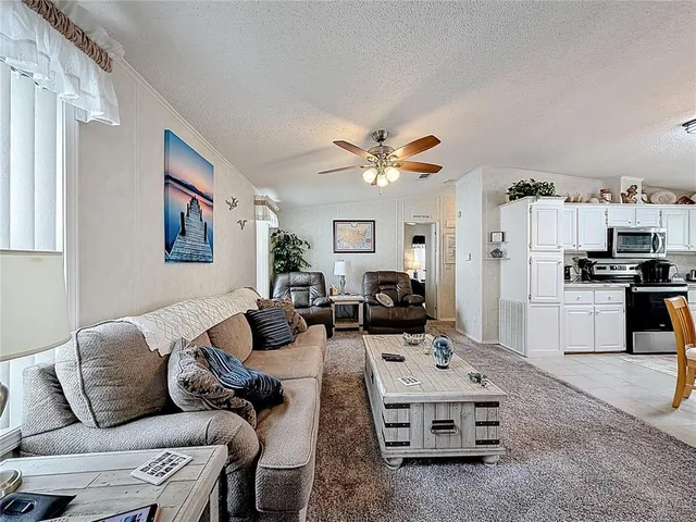 a living room with furniture and kitchen view