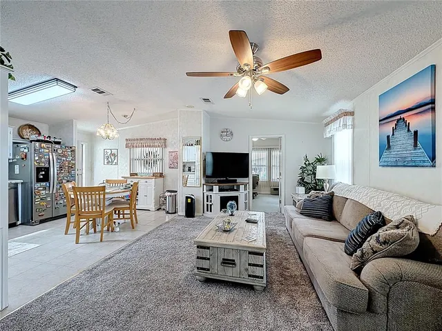 a living room with furniture ceiling fan and a flat screen tv