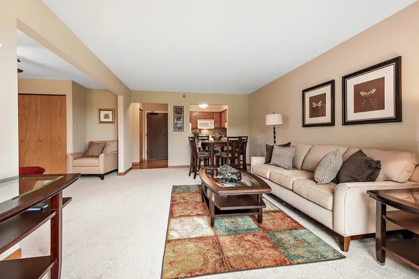 a living room with furniture and a dining table with wooden floor