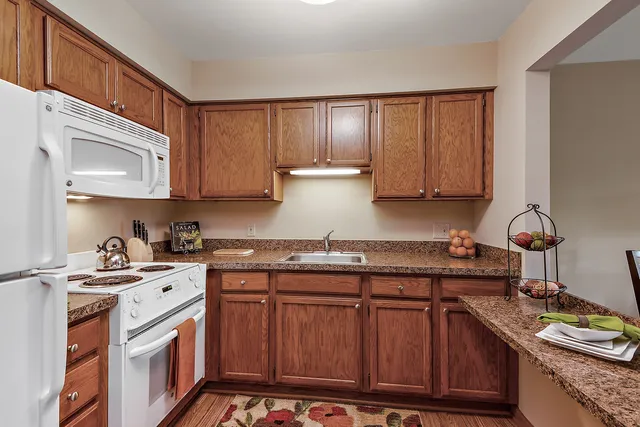 a kitchen with stainless steel appliances granite countertop a sink stove and cabinets
