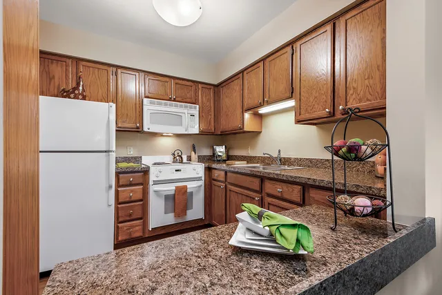 a kitchen with stainless steel appliances granite countertop a refrigerator stove sink and cabinets