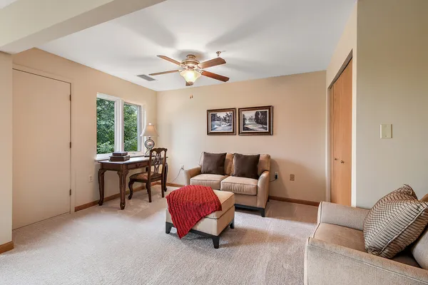 a living room with furniture a window and a ceiling fan