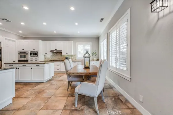 a kitchen with a dining table chairs and white appliances
