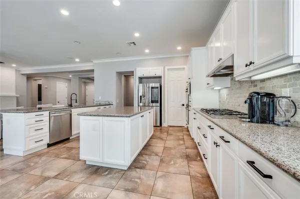 a large kitchen with stainless steel appliances lots of counter space sink and cabinets