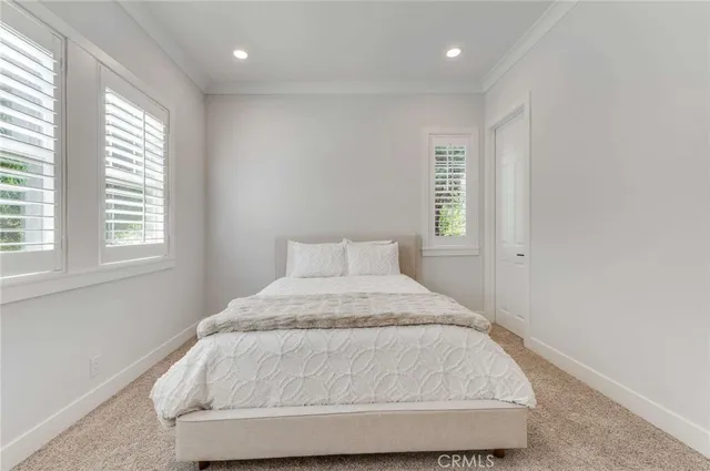 a bed sitting in a bedroom next to a window