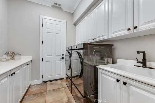 a utility room with sink dryer and washer
