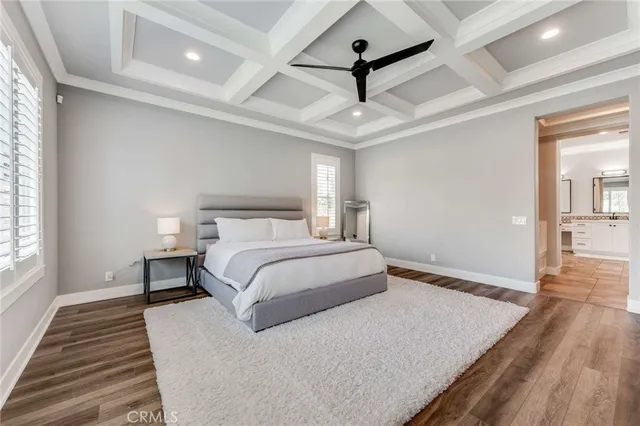 a bedroom with a large bed and a chandelier