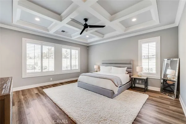 a spacious bedroom with a large bed a chandelier and a large window