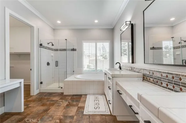 a spacious bathroom with a tub sink and mirror