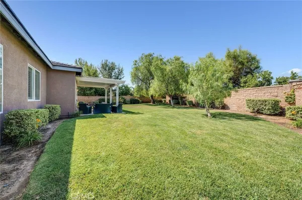a view of a big house with a big yard and potted plants